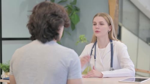 Young Doctor Talking with Patient in Clinic