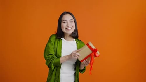Young Woman Offering a Beautifully Wrapped Present
