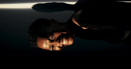 Smiling Young Adult Close Up in Dark Lighting