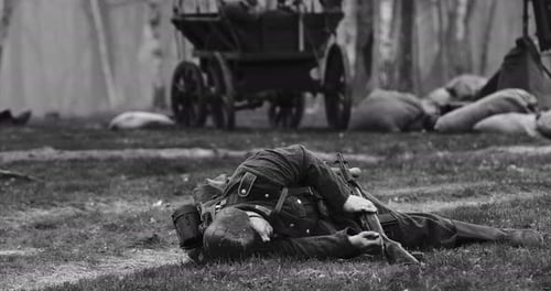 Close Up View On Reenactor Dressed As German Wehrmacht Soldier Lies Slain In Reconstruction Of