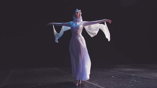 Elegant Ballerina Dances Gracefully on a Dark Stage