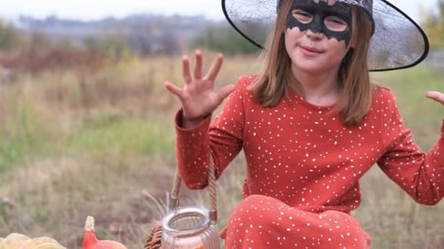 Little Girl in Witch Costume Makes Spooky Gestures