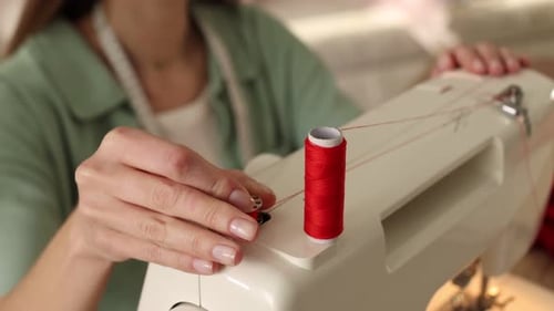 Woman working with sewing machine in workshop, closeup