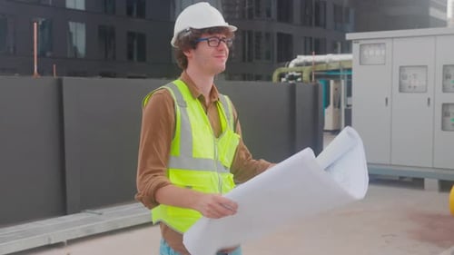 Architekt junger Mann mit Helm auf der Suche nach Blaupause für Inspektion und Bauplanung.