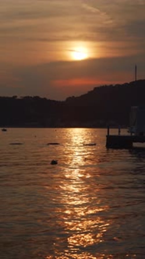 Vertical video of sunset over the sea. Summer holiday and vacation background for social media.