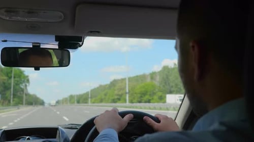 Young Man Looking Straight While Driving a Car While Concentrating on the Road Right Hand Drive Car