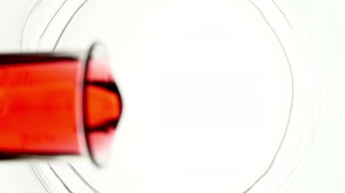 Liquide versé dans un bécher avec de l'eau provenant d'un flacon en verre sur fond blanc The Medicine Concept