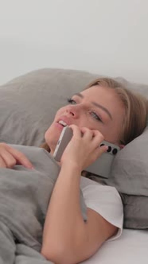 Woman Talking on Phone Lying in Bed