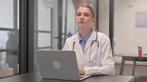Woman Doctor Typing on Laptop in Office