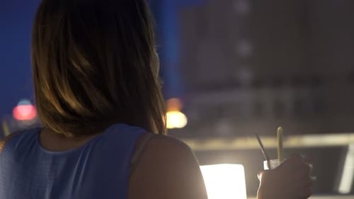 Young Woman Admire View and Drinking Cocktail on Terrace in Bar At