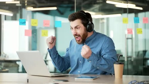 Excited Man Celebrating Success in Modern Workplace
