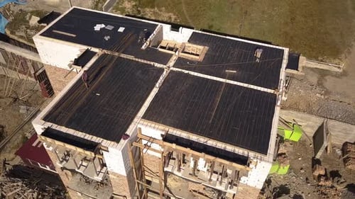 Luftaufnahme von Bauarbeitern, die auf einer Baustelle eines Wohnhauses arbeiten