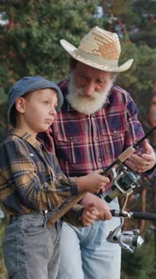 Close Up of Goodtempered Experienced Mature Greybearded Granddad in Straw Hat Which Fishing Together
