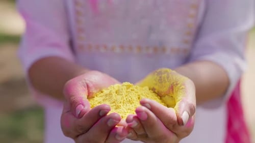 Hands Holding Bright Yellow Holi Powder