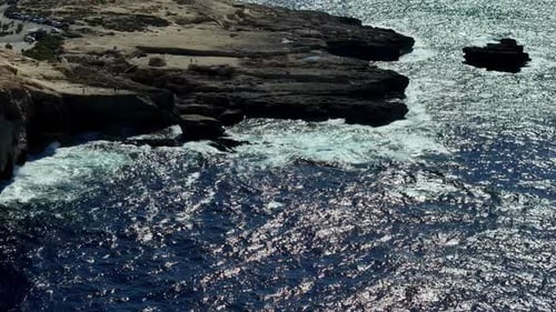 Dramatic high angle aerial view of the rugged limestone coastline of Gozo Malta during a bright