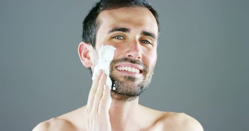 Man Applying Shaving Cream to Face in Studio