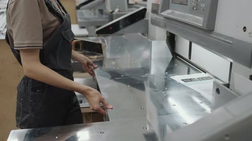 Unrecognizable Woman Using Cutter In Print Shop