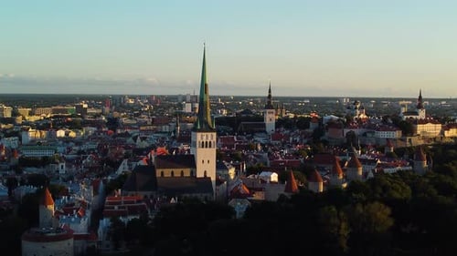 Stunning aerial slow motion dolly of tallinn's historic old town at sunset, showcasing iconic church
