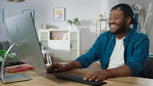 Portrait of the Happy African American Man Laughing at the Video He Watched on His Personal Compute
