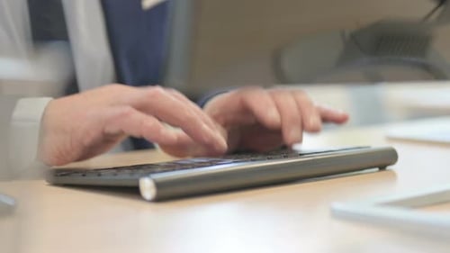Side View of Senior Old Businessman Typing on Keyboard at Work