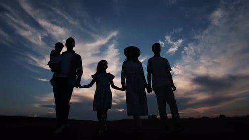 Dad Mom and Children are Walking at Sunset in the Park
