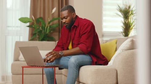 Portrait of African American Businessman Talking on Phone Use Laptop Working From Home Office