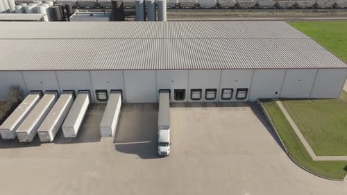 Aerial View of Semi Trucks Docking at Large Industrial Warehouse