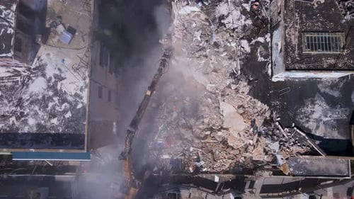 Vue du dessus d'un bulldozer qui déblaie les décombres de bâtiments effondrés dans la rue David Bloch à Tel Avi