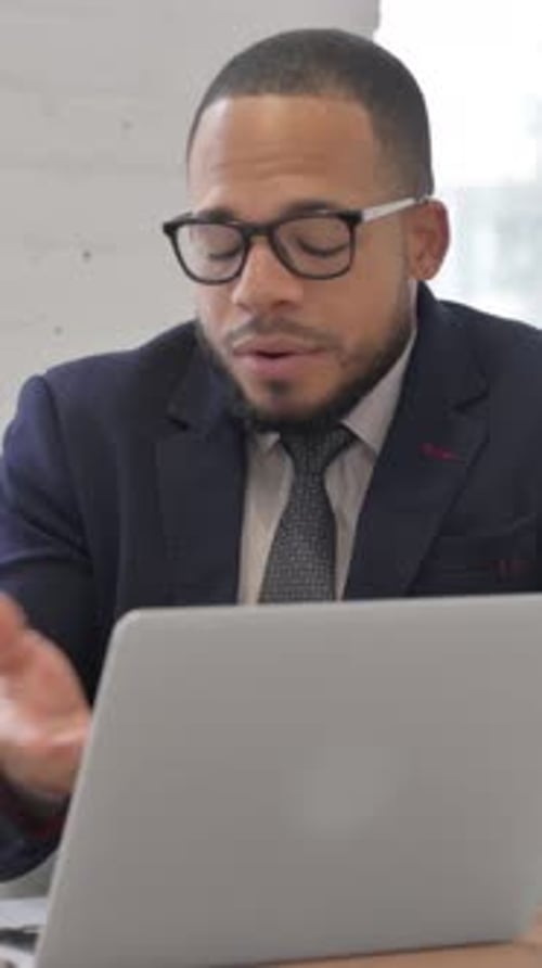 Man Video Conferencing with Laptop in Office