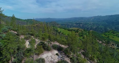 4k 29 FPS drone shot where the vast land is revealed as the drone passes over a hill. This is a push