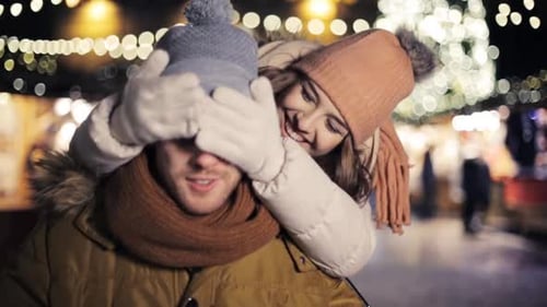 Romantic Young Couple at Christmas Market at Night