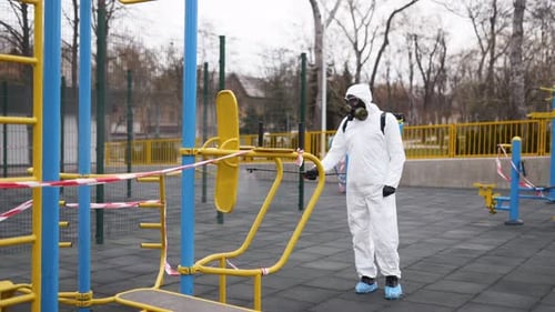 Disinfecting Playground Equipment with Sprayer and Hazmat Suit