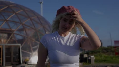 Woman In Front of Urban Greenhouse on Sunny Day
