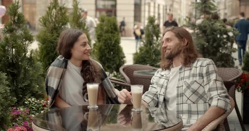 Young Couple Man and Woman Sitting at Table Trendy Cafe on a Summer Day