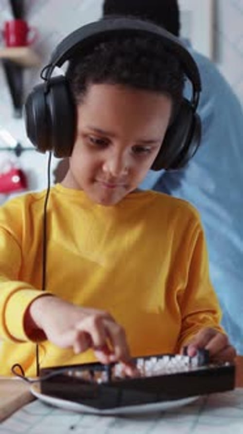 Little African Talented Boy Wearing Headphones Creating Music on Sound Mixer While His Parents