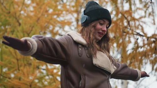 Closeup of Female with Outstretched Arms Walking Joyfully on Cool Autumn Day