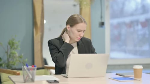 Businesswoman Working and Experiencing Neck Pain at Desk