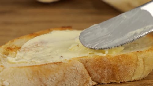 Butter Being Spread on Bread Slice