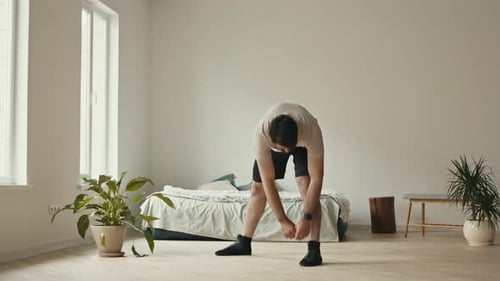 Man Stretching in Bedroom for Fitness and Flexibility