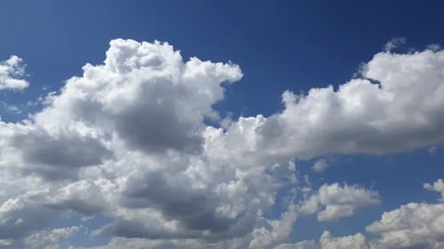 Blue summer sky with dense thick rain clouds moving across the heavens. Fast cloud formation and mov