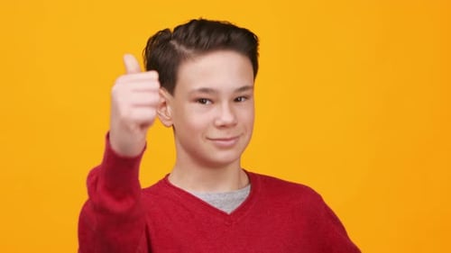 Junge zeigt Daumen hoch vor hellgelbem Hintergrund mit klaren Gesichtsausdrücken in hochwertigem Filmmaterial