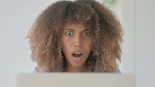 Close Up of African Woman Reacting to Loss on Laptop
