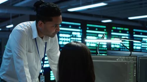 IT Team Monitors Cybersecurity Risks in Server Room Using Computer Workstation