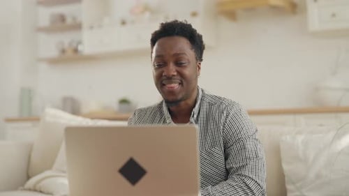 Man Smiles during Video Call at Home