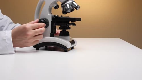 Microscope Adjustment by a Man in a Lab Coat