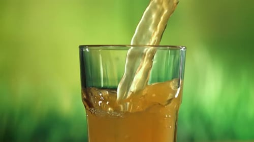 Pouring Fresh Orange Juice into Glass