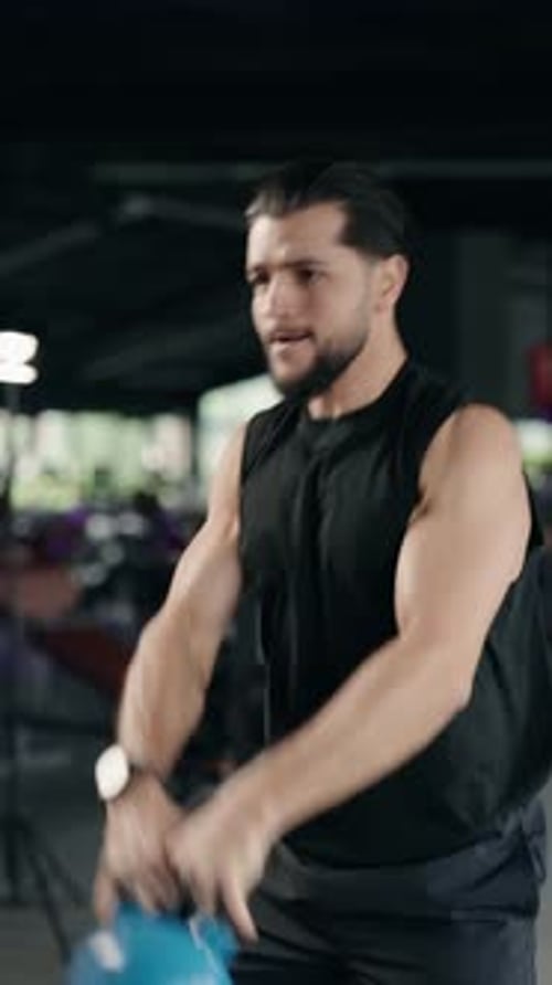 Muscular Athlete Performing Kettlebell Swings in the Gym