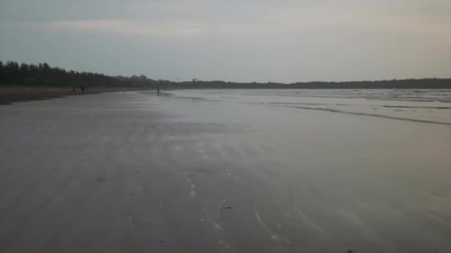 Landschaftsblick auf eine tropische Sandküste an einem bewölkten Abend