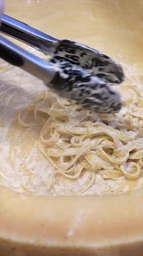 Pasta Being Prepared Within Hard Cheese Wheel