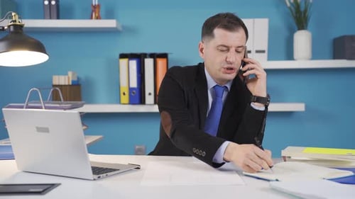 Businessman working in office making phone call about business.